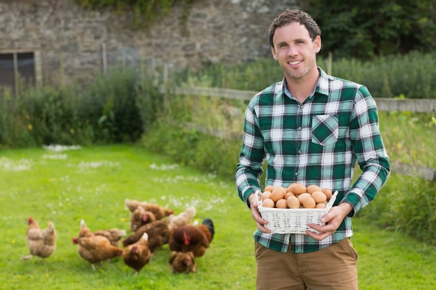 Fier jeune homme tenant un panier rempli d&#39;oeufs