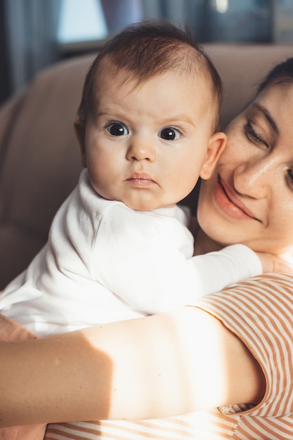 Fière mère caucasienne tient son bébé nouveau-né en lui souriant