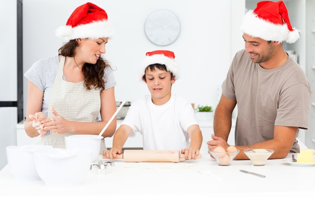 Fiers parents regardant leur fils à l&#39;aide d&#39;un rouleau à pâtisserie