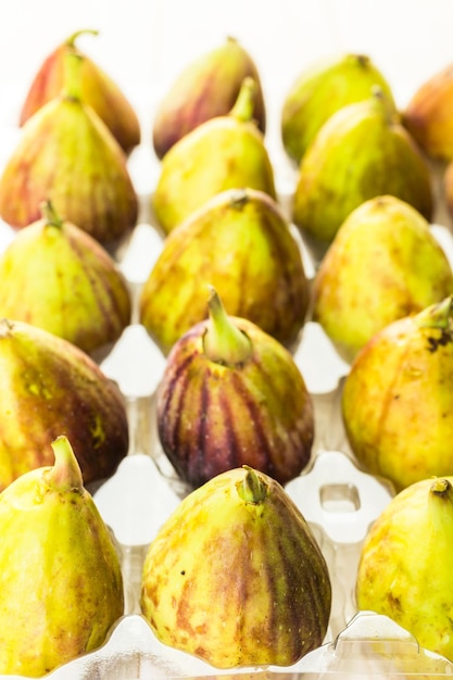 Figues de Californie biologiques dans une caisse en plastique sur une table en bois.