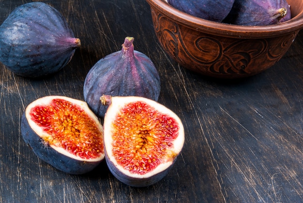 Photo figues crues mûres sur une table en bois noir