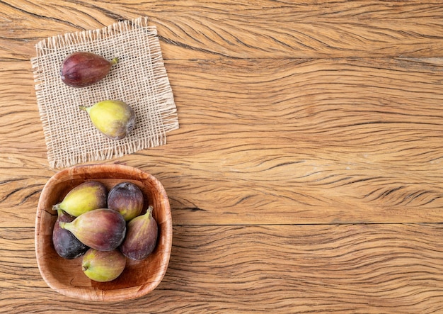 Figues dans un bol sur une table en bois avec espace de copie