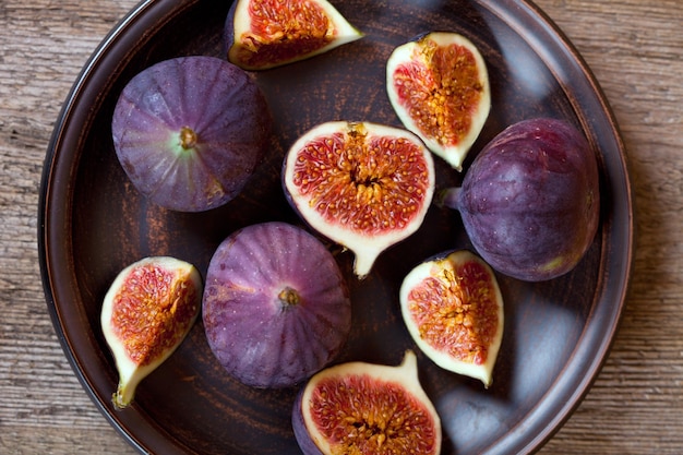 Des figues fraîches dans une assiette sur une table en bois rustique