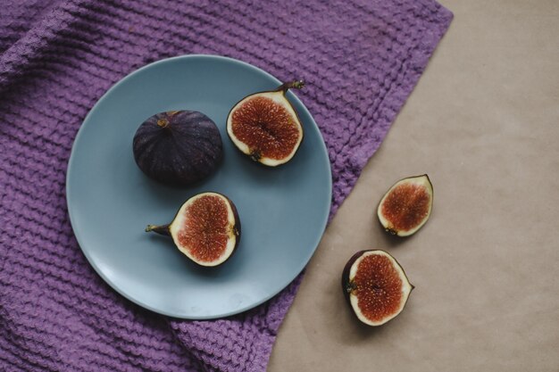 Figues fraîches mûres et textiles violets sur fond rustique vue aérienne flatlay