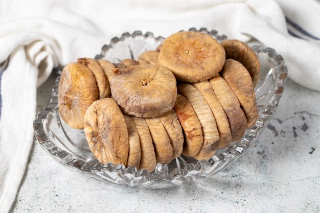 Figues séchées sur fond de pierre Figues sèches à la soie dans un bol de verre Aliments diététiques en gros plan