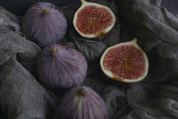 Figues sur tissu sombre dans une boîte en bois sur fond de pierre sombre, mise au point sélective