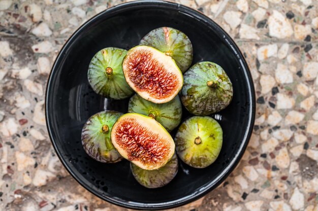 Figues vertes bio sucrées sur une assiette. Vue de dessus. Fond gris.