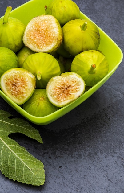 Figues vertes, fraîches et mûres. Avec une feuille de vigne.