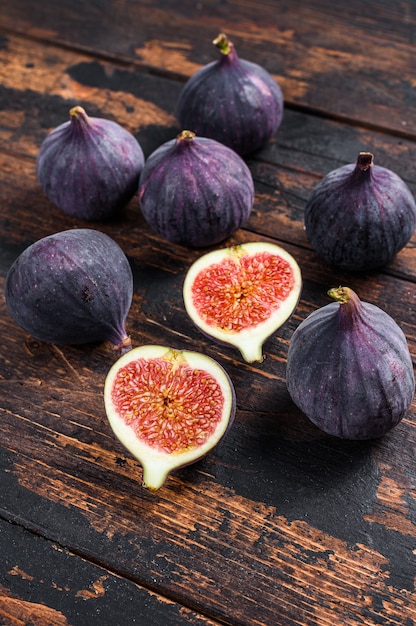 Figues violettes sur une table en bois. Table en bois sombre. Vue de dessus.