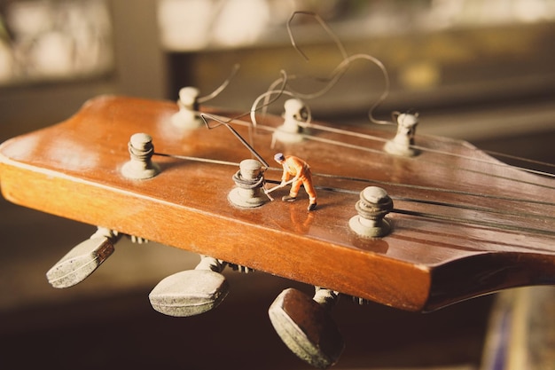 La figure du travailleur technicien réparant les vieilles cordes de guitare