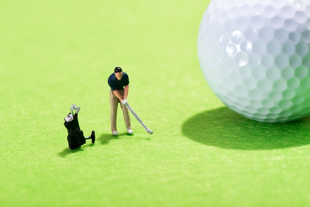 Photo figure miniature d'un golfeur jouant un coup