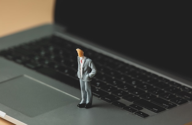 Figure miniature d'un homme d'affaires sur un ordinateur portable