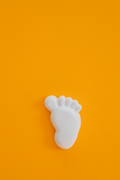 Figure en plâtre d'un pied sur fond jaune