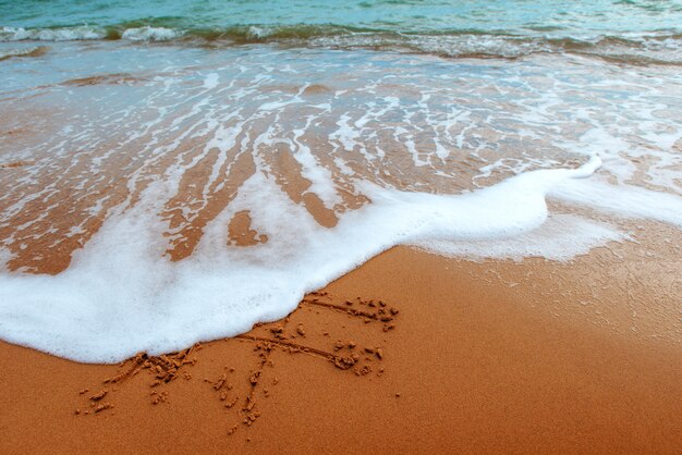 Figures dans le sable sur la plage