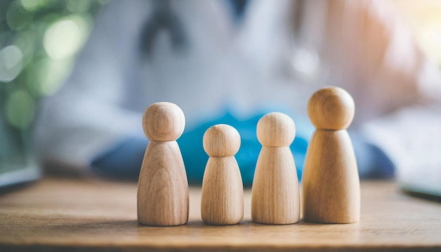 Figures de famille en bois miniatures sur une table de médecins symbolisant l'unité et le soutien aux soins de santé dans un c