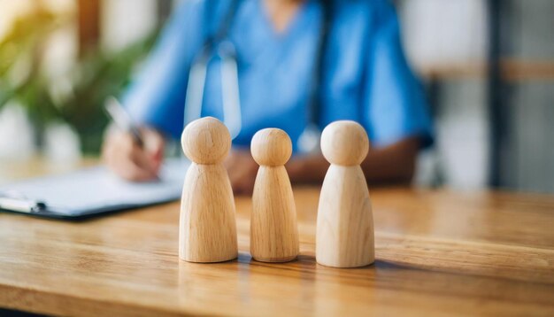 Figures de famille en bois miniatures sur une table de médecins symbolisant l'unité et le soutien aux soins de santé dans un c