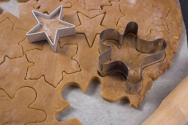 Figures D'hommes Sculptées Dans La Pâte à Pain D'épice Sur Parchemin, Cuisson Du Pain D'épice. Joyeux Noël.