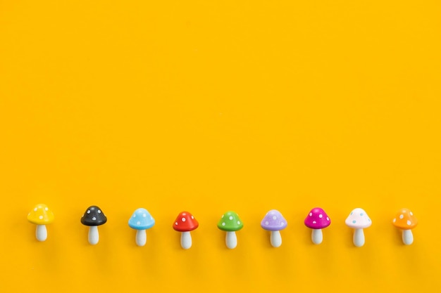 Figures sous forme de champignons colorés sur fond jaune