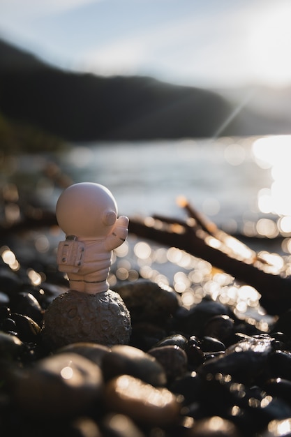 Photo une figurine d'astronaute se tient sur le rivage et fait des vagues vers la mer