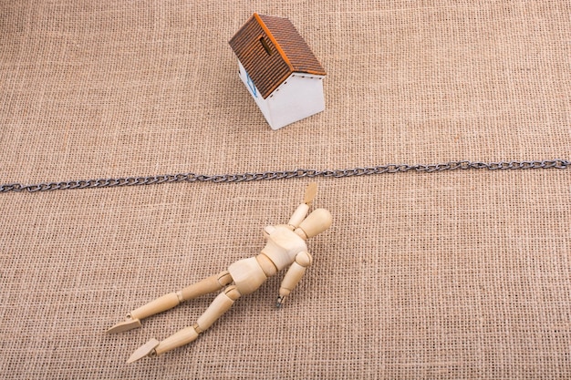 Figurine homme et une maison modèle au-delà de la chaîne