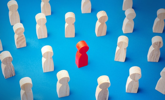 Photo figurine homme rouge dans une foule de gens se distingue de la foule différente spéciale