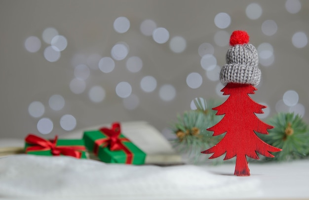 Figurine rouge d'un arbre de Noël dans un chapeau sur un arrière-plan flou. Décoration du nouvel an.