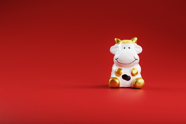 Figurine de vache sur fond rouge, concept du nouvel an