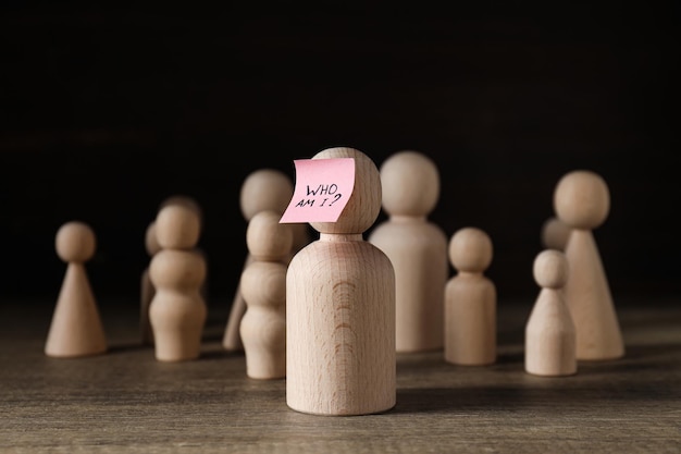 Figurines en bois avec note rose avec texte sur fond sombre