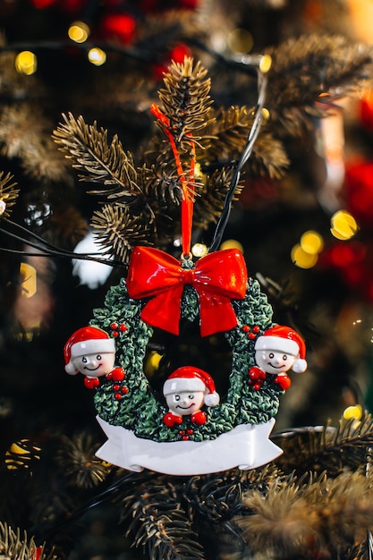Figurines de jouets de Noël d'Elfes dans un chapeau de Père Noël accroché aux branches d'arbres de Noël