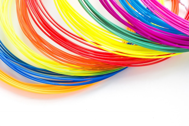 Filaments en plastique arc-en-ciel coloré pour stylo 3D portant sur fond blanc. Nouveau jouet pour enfant.