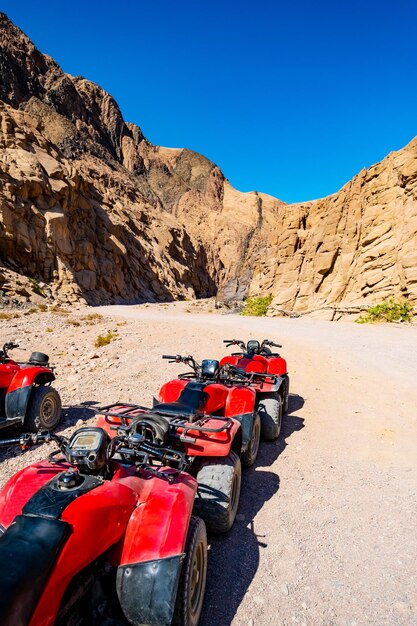 File d'attente de quads rouges en safari près des gorges des montagnes