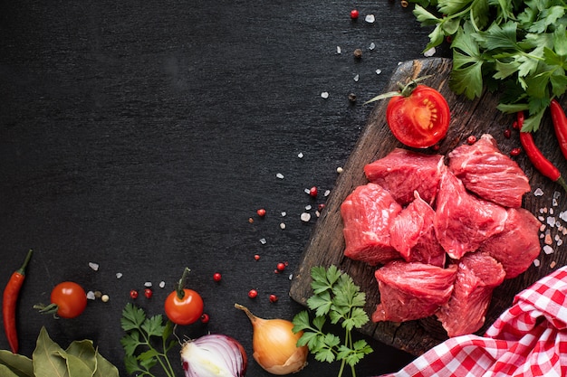 Filet de boeuf cru prêt à griller. Filet de veau sur une planche à découper en bois avec tomates cerises, piment et herbes. Ingrédients pour soupe ou bortsch. copier l'espace. vue de dessus.