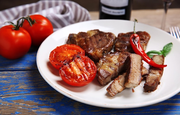 Filet de boeuf rôti et légumes grillés sur plaque sur fond de bois