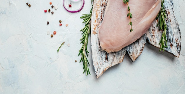 Filet de dinde crue sur planche à découper, ingrédients de cuisine. Concept d'aliments sains naturels. Format de bannière longue. vue de dessus,