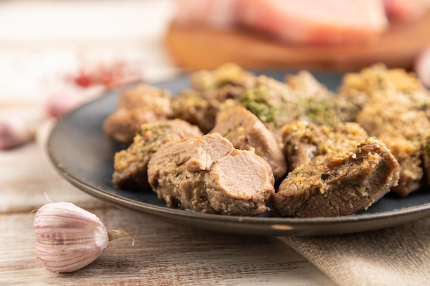 Filet de dinde cuit à l'ail sur fond de bois blanc vue latérale mise au point sélective