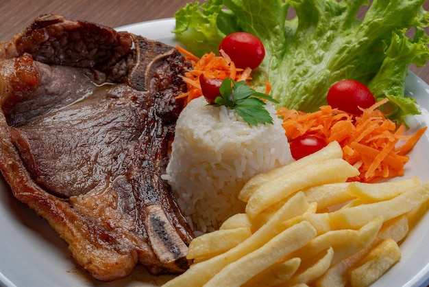 Filet frites servi avec riz et laitue salade de tomates et carottes