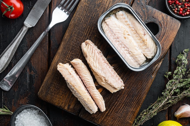 Filet de maquereau en conserve, conserves de poisson, sur une planche à découper en bois, sur la vieille table en bois sombre