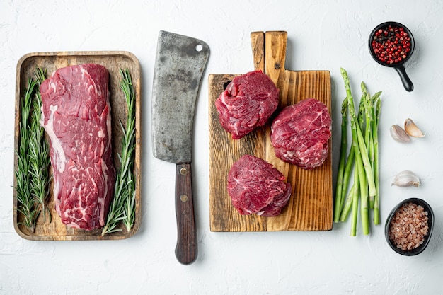 Filet mignon filet de viande crue de veau et de steaks de boeuf, sur une planche à découper en bois, sur une surface en pierre blanche