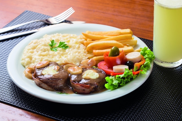 Filet mignon avec frites, riz, salade et jus de citron