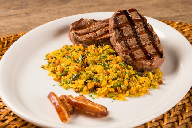 Filet mignon grillé sur assiette avec chapelure et bacon.