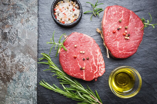 Filet mignon de viande crue marbrée avec assaisonnements sur pierre.