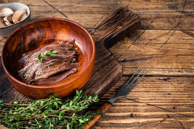 Filet de poisson anchois en conserve dans un bol en bois