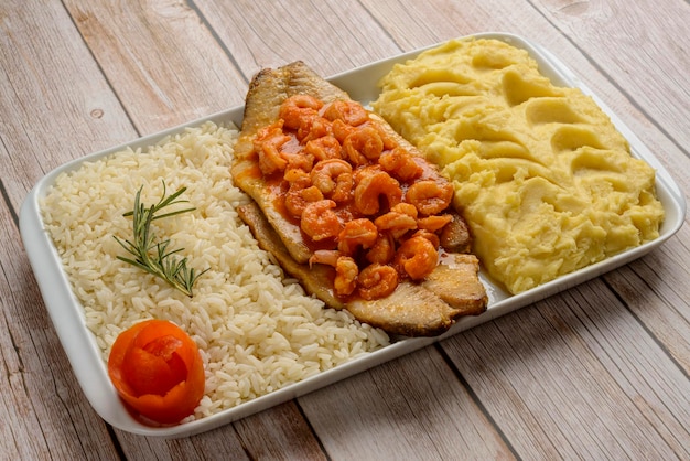 Filet de poisson aux crevettes à la sauce tomate accompagné de riz blanc et purée de pommes de terre