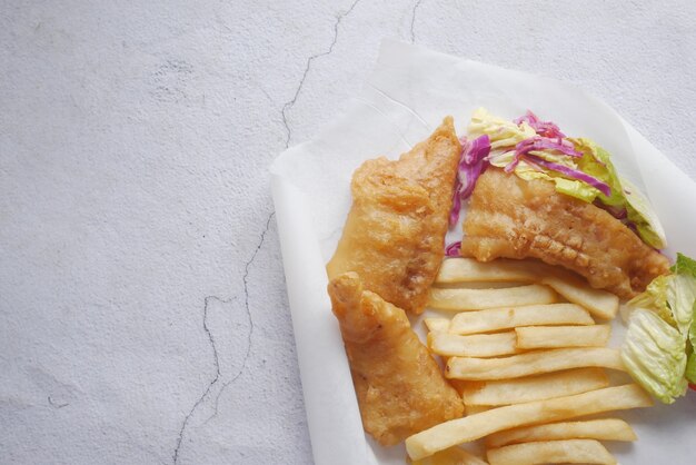 Filet de poisson chips de citron et purée de pommes de terre sur un papier sur mesure