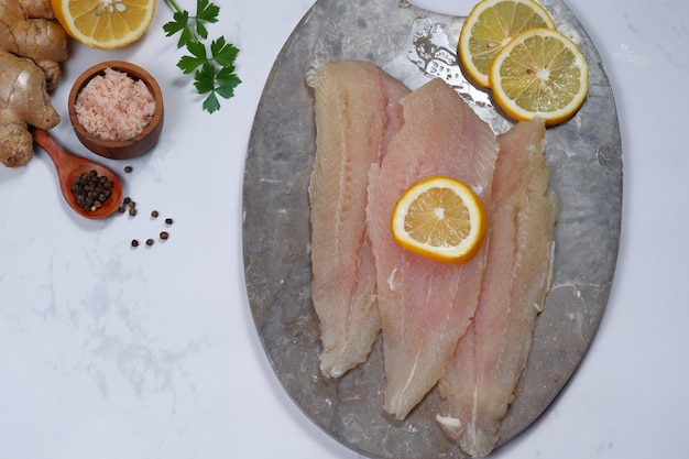 Photo filet de poisson frais pangasius dory avec ingrédient sur fond blanc