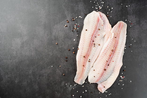 Filet de poisson pangasius cru aux épices sur fond de béton