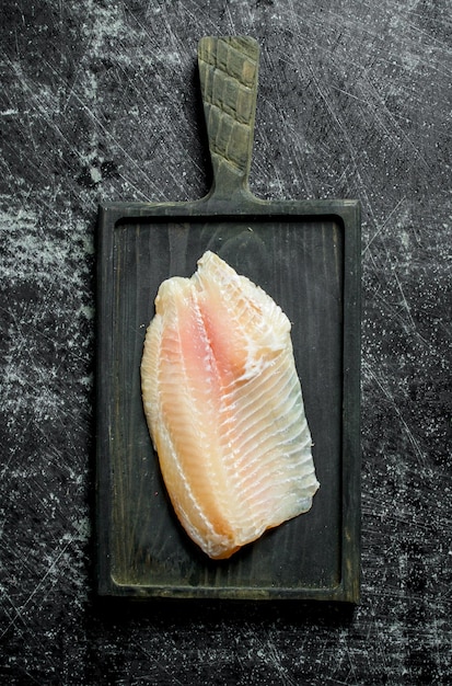 Filet de poisson sur une planche à découper noire