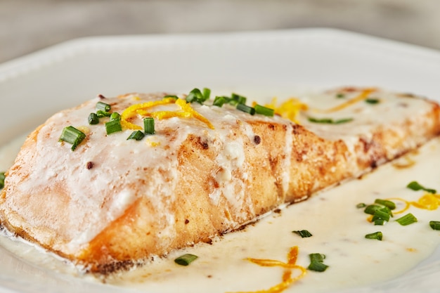 Filet de poisson saumon en sauce béchamel avec zeste d'orange et oignons verts. Cuisine française Cuisine gastronomique.