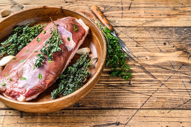 Filet de poitrine de canard de volaille crue non cuite aux herbes. fond en bois. Vue de dessus. Espace de copie.