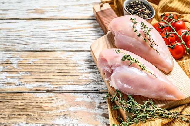 Filet de poitrine de poulet cru frais, viande biologique. sur une planche à découper